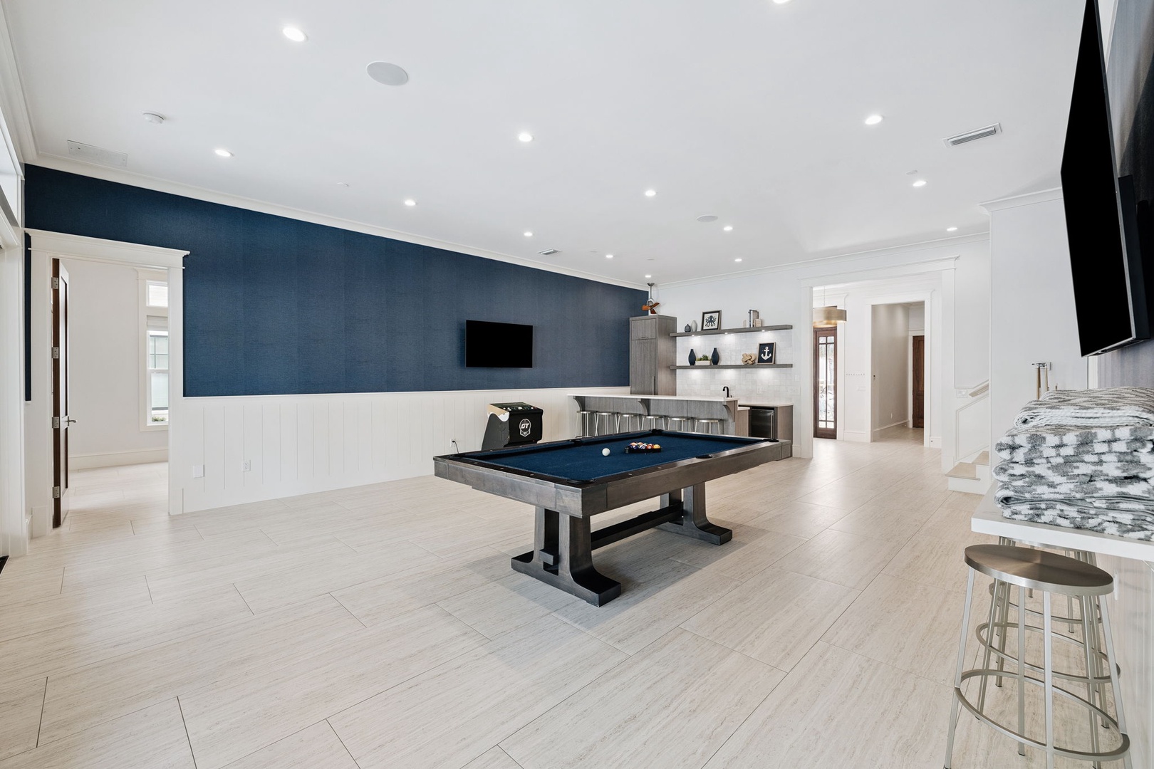 Step into your entertainment paradise with a stunning pool table, modern kitchen, and flat-screen TVs creating the perfect space for memorable moments.