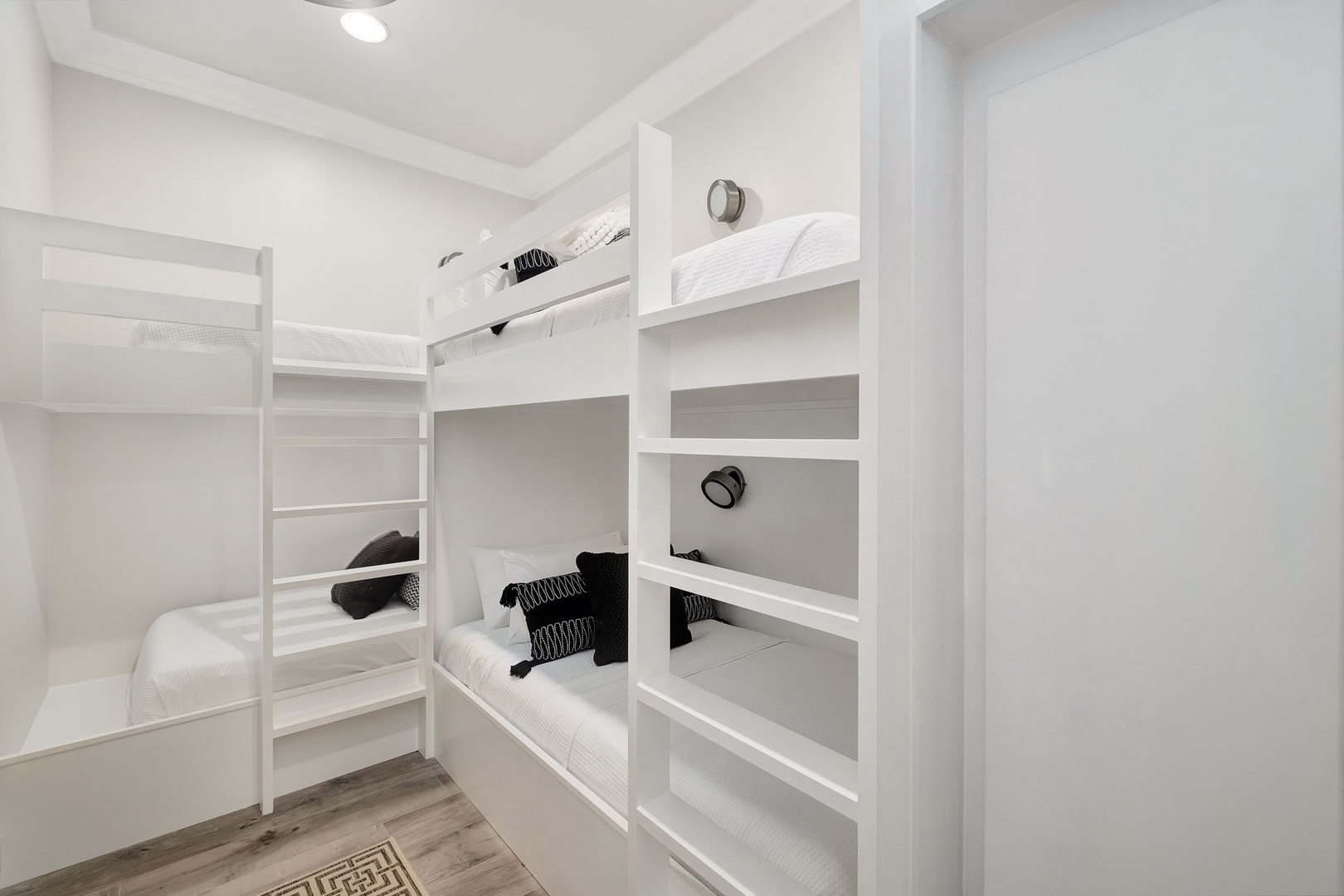 Your cozy bunk room sleeps four in comfort with crisp white linens, individual reading lights, and clean modern design for restful nights.