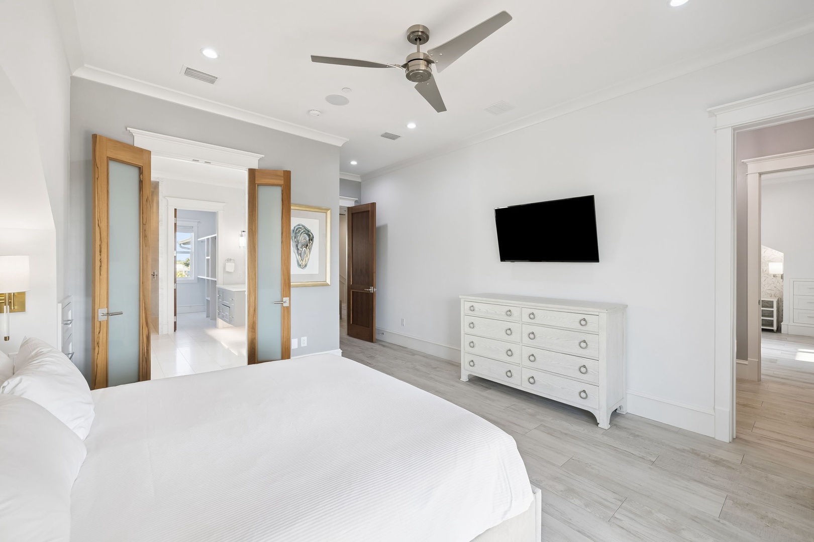 Unwind in your spacious master bedroom featuring crisp white linens, modern amenities, and calming tones for peaceful nights.