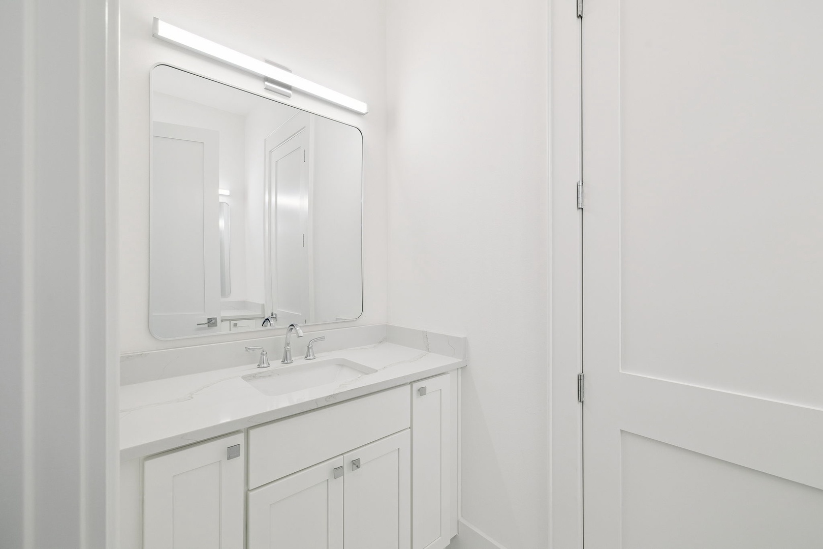 Step into your pristine white bathroom featuring elegant marble countertops and modern LED mirror lighting for your morning routine.