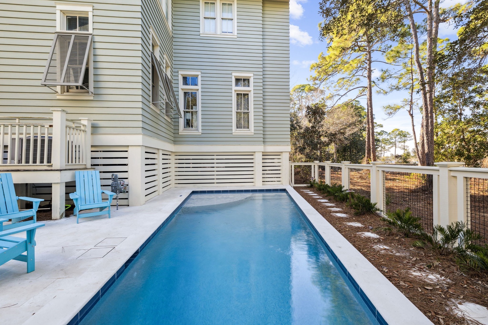 Dive into your private oasis with crystal-clear waters and comfortable poolside seating under towering coastal pines.