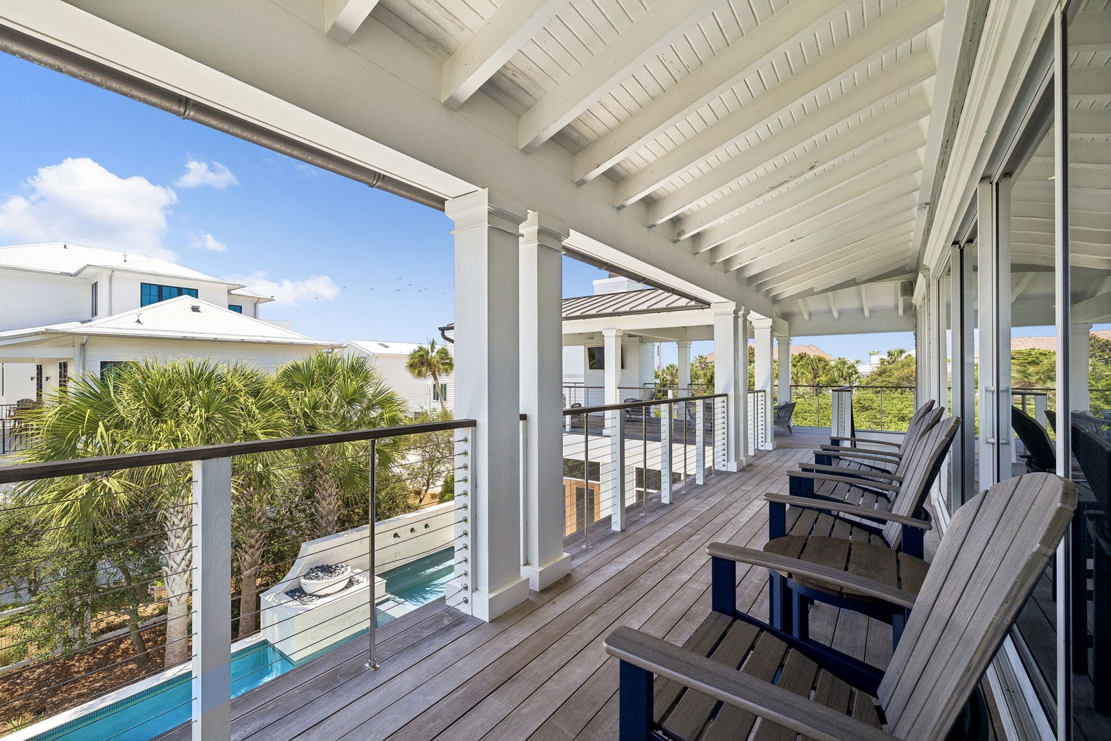 Settle into your private balcony with sweeping views of lush palms and the sparkling pool below. This covered terrace invites you to unwind in comfort, where coastal breezes and serene surroundings create the perfect escape.
