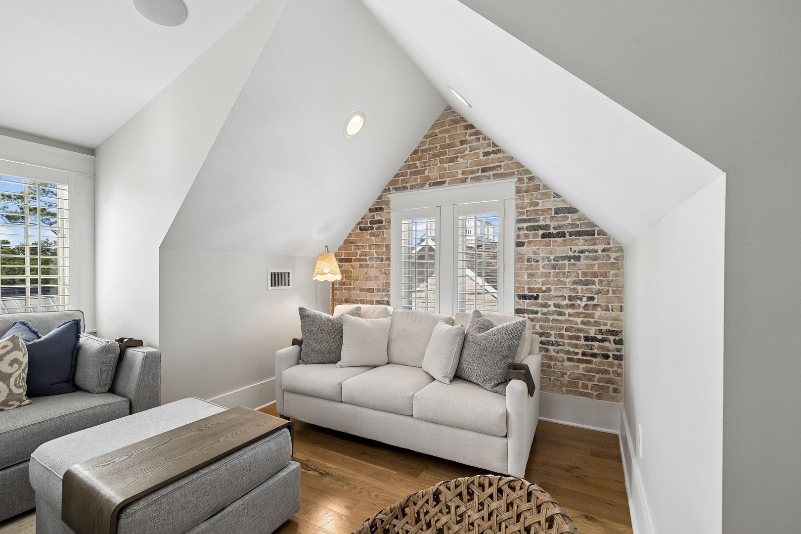 Sink into plush sofas beneath soaring vaulted ceilings and warm exposed brick. Your cozy loft retreat is filled with natural light, inviting you to unwind in style.