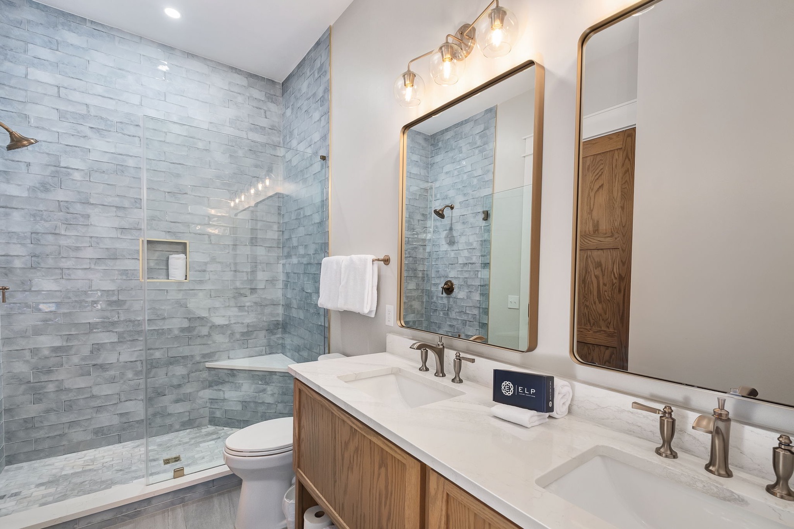 Unwind in your spa-like bathroom featuring marble subway tiles, dual vanities, and a luxurious walk-in shower with premium amenities.