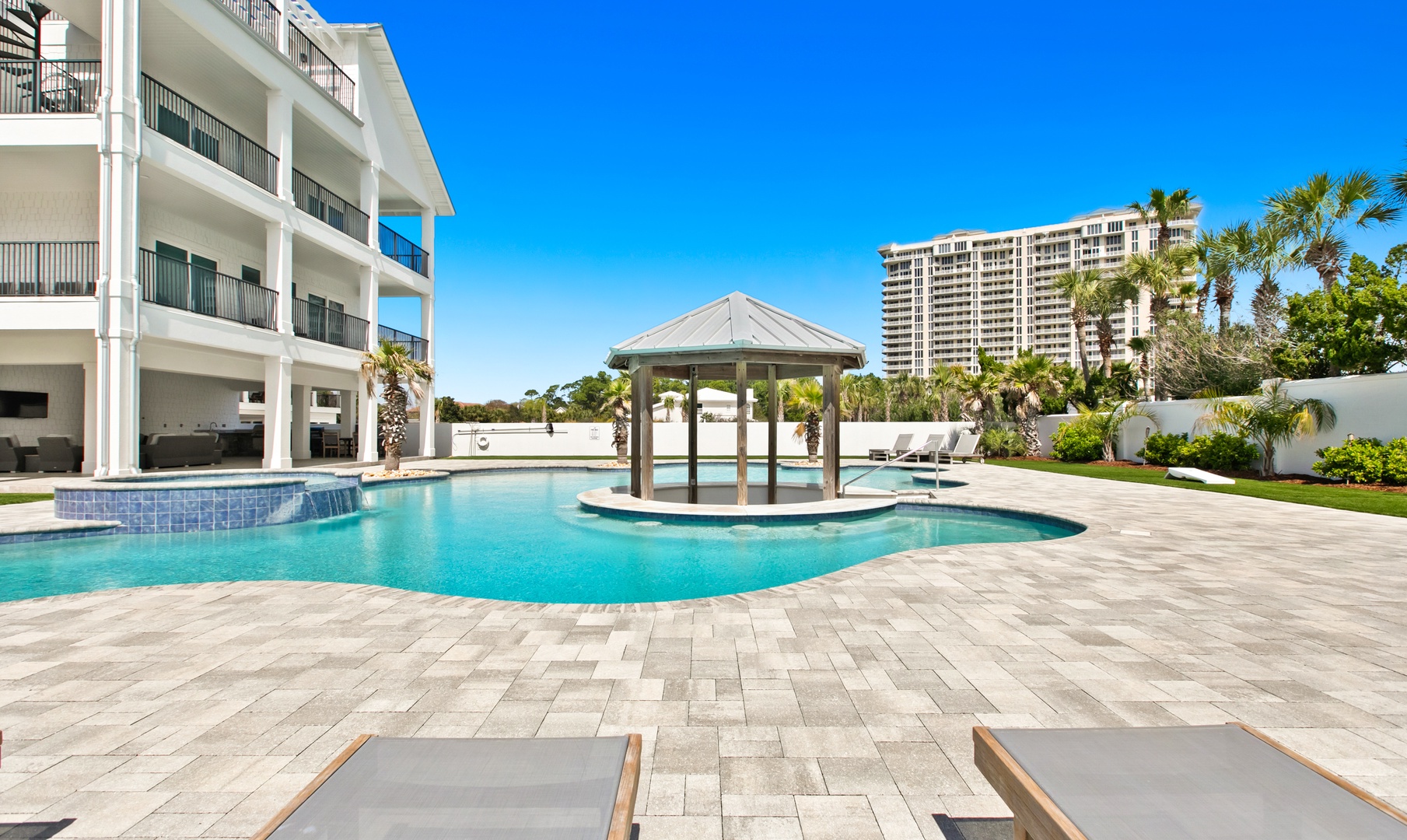 Soak up the sun by the sparkling pool, surrounded by swaying palms and peaceful tropical landscaping. Your private retreat features a unique gazebo island, perfect for lounging under clear blue skies.