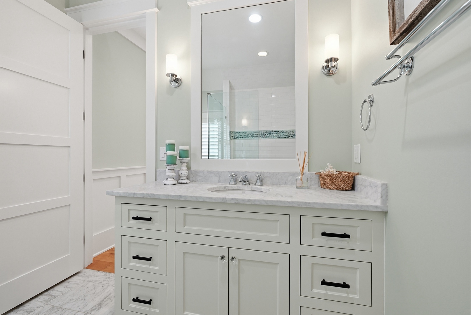 Step into your serene private bathroom, where elegant marble counters and crisp white cabinetry create a spa-like sanctuary for your morning and evening routines.