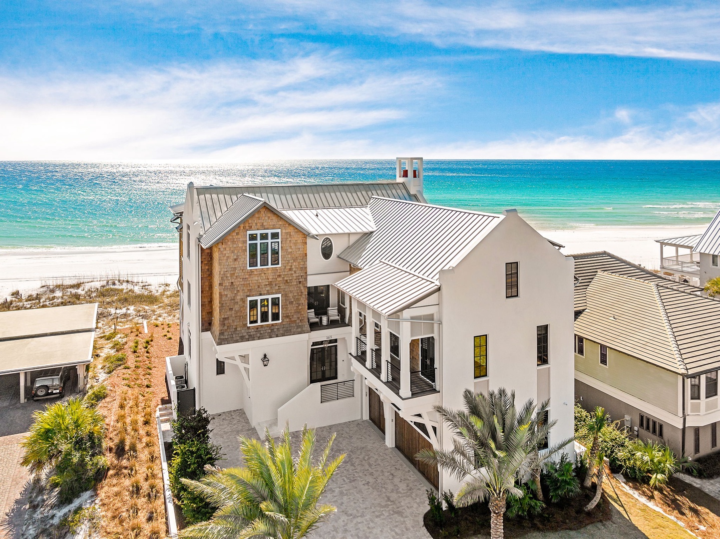 Stunning beachfront property with pristine white sand and turquoise waters just steps away from the elegant coastal home.