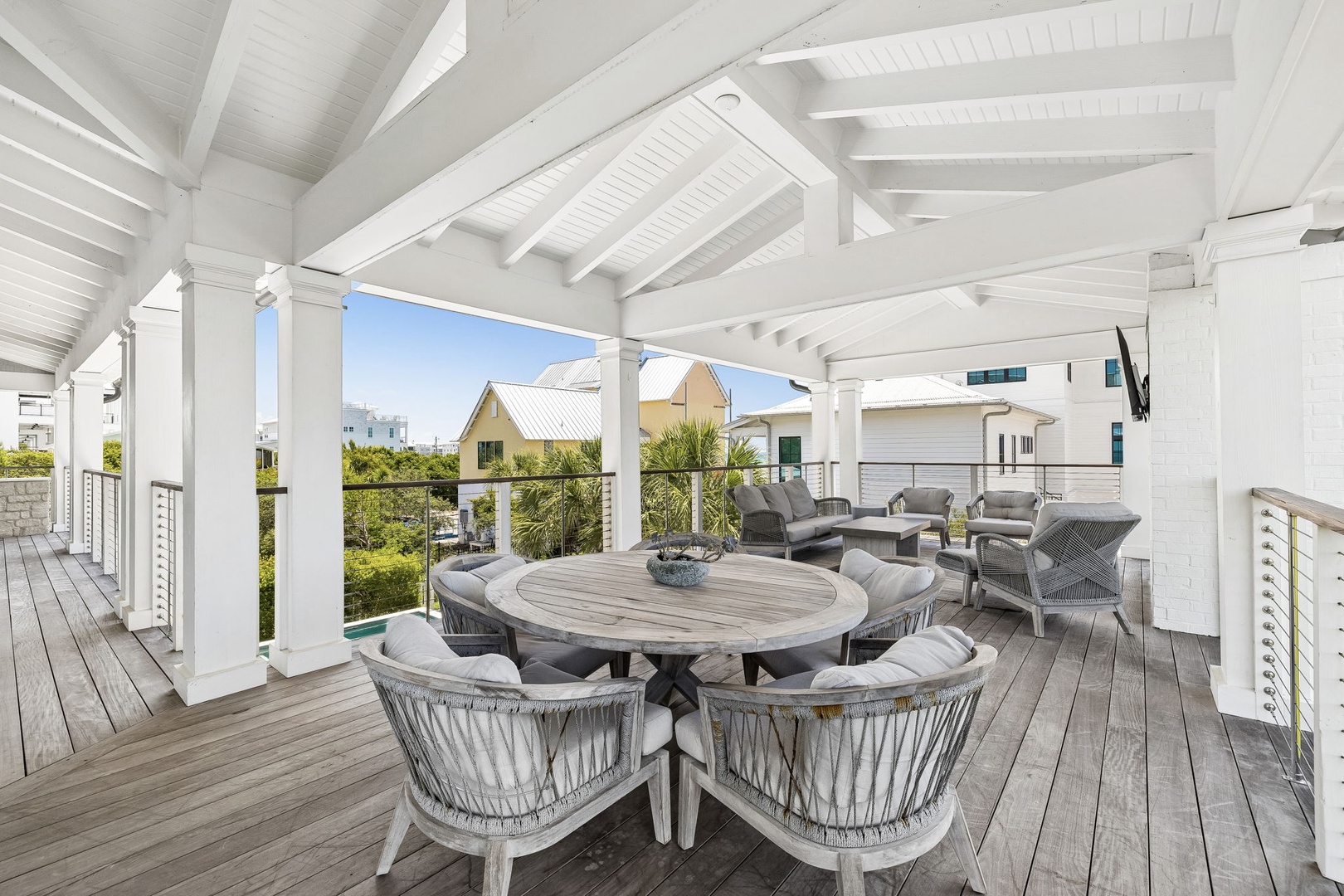 Gather around your private dining table under open beams, or lounge in plush seating on this covered deck—perfect for morning coffee and long evening conversations overlooking the neighborhood.