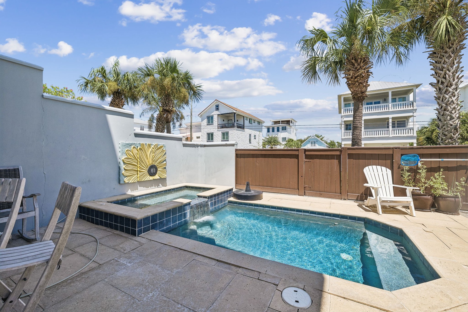Your private pool awaits, framed by swaying palms and sunny skies—perfect for cooling off or soaking in the hot tub after a beach day.