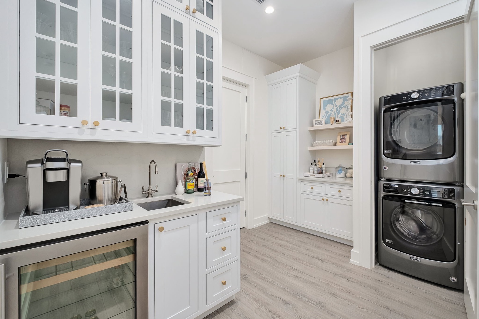 Your bright, organized utility space features full-sized washer and dryer, a sink with marble-style countertop, and plenty of custom storage—making laundry day effortless.