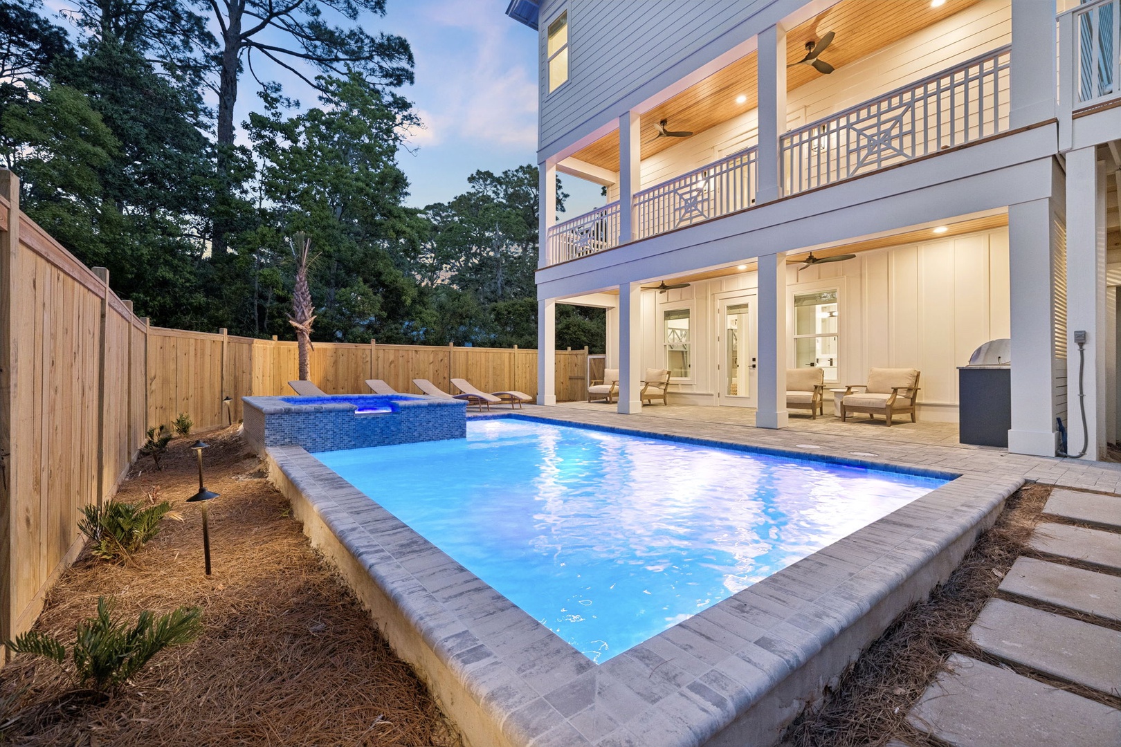 Modern coastal retreat with private pool, spacious balconies, and ambient lighting perfect for relaxing evenings surrounded by lush greenery and thoughtful design.
