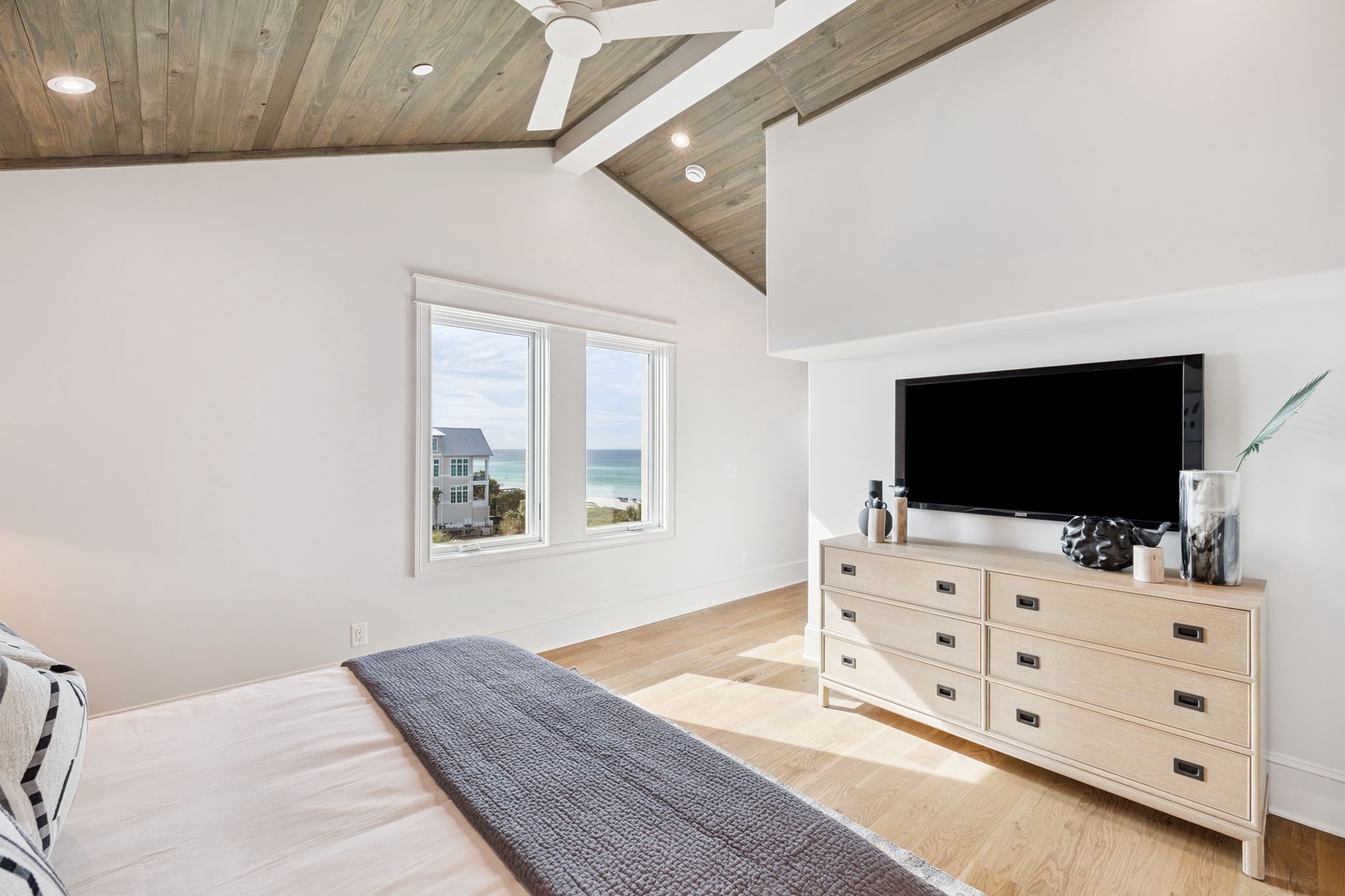Wake up to stunning ocean views from your bed. The serene coastal landscape visible through your bedroom window creates the perfect backdrop for a peaceful beach getaway.
