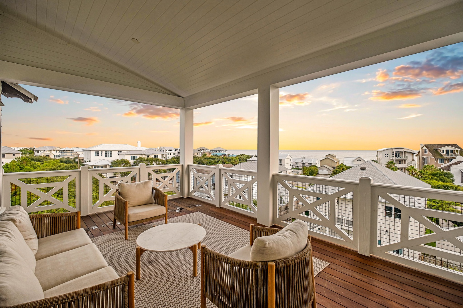 Unwind on your private covered porch with coastal views stretching to the horizon. Comfortable seating invites you to savor warm sunsets and gentle ocean breezes in this peaceful retreat.