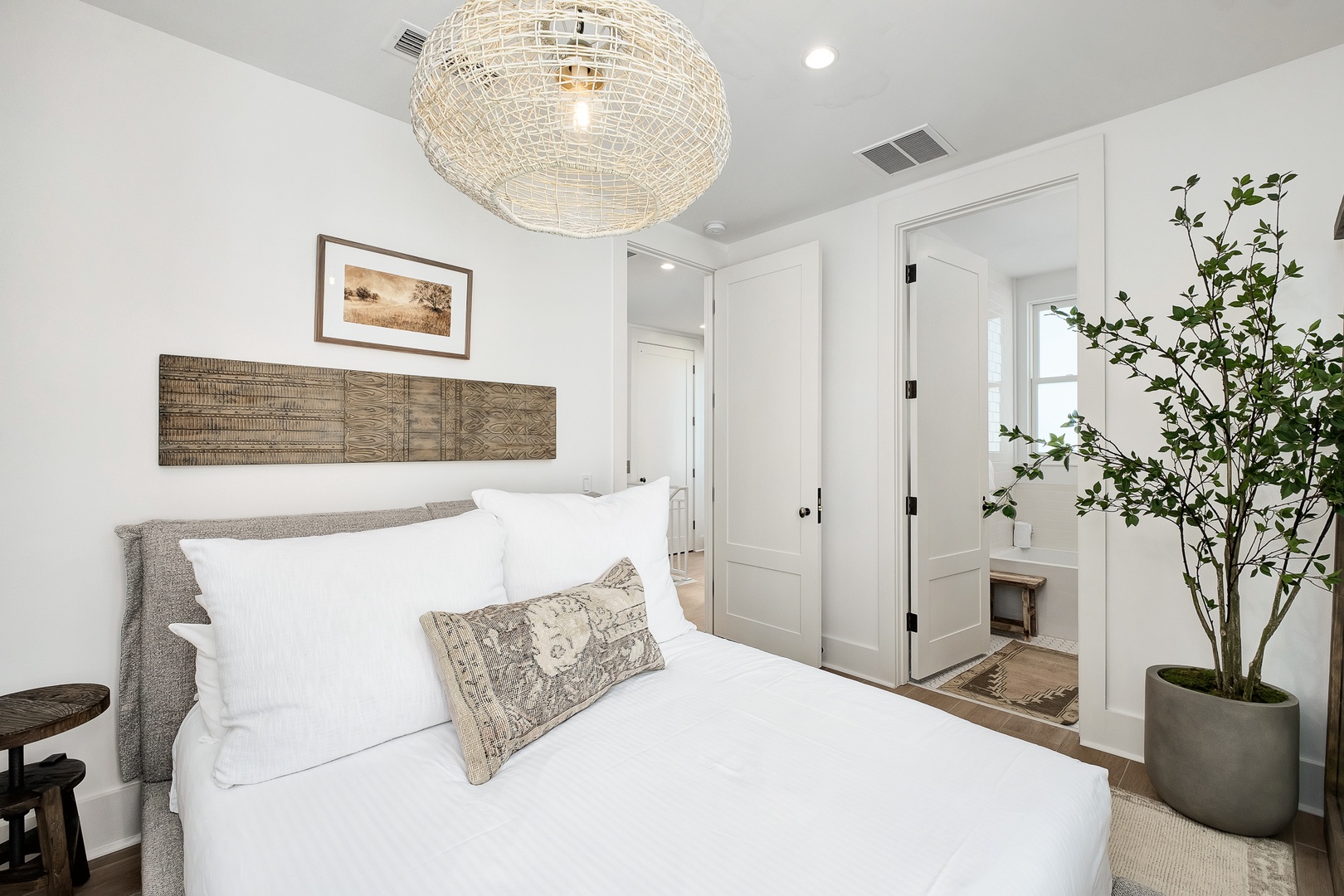 Drift off in your serene bedroom sanctuary with crisp linens, warm wood accents, and elegant woven lighting creating the perfect peaceful retreat.