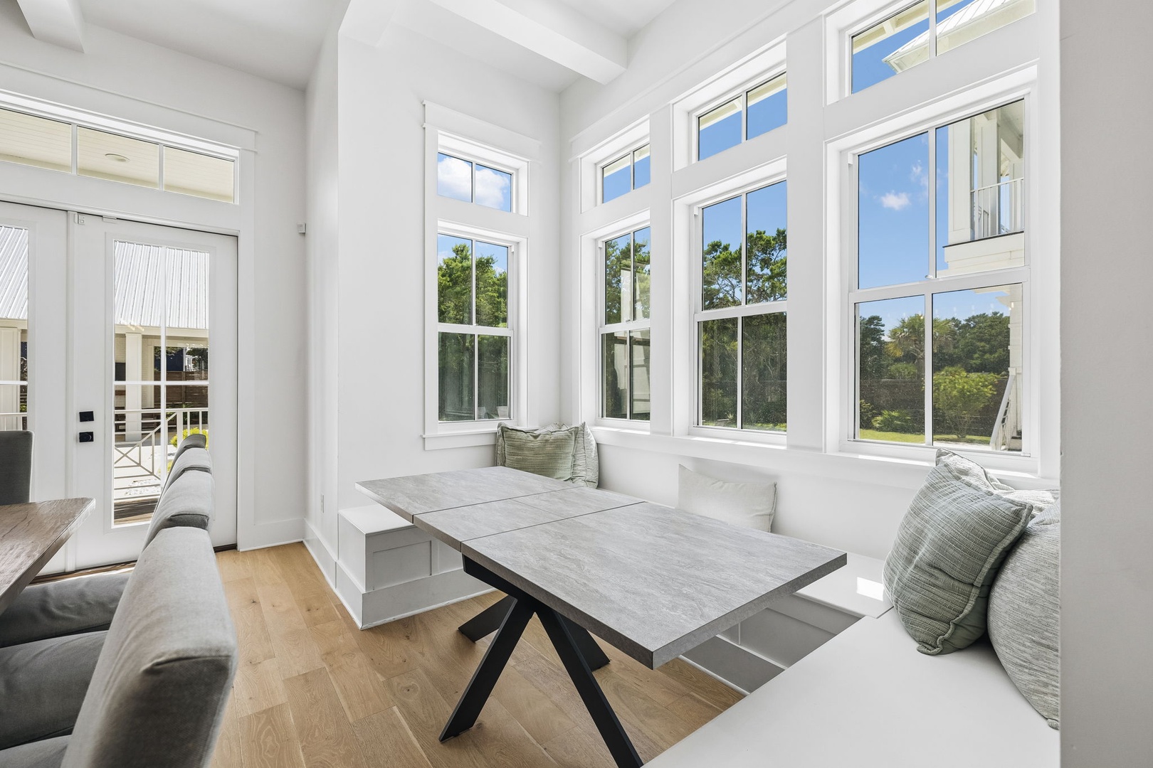 Settle in at your sunlit dining nook with plenty of space to share meals and stories. Natural light pours through tall windows framing peaceful treetop views, while built-in seating keeps everyone close and comfortable.