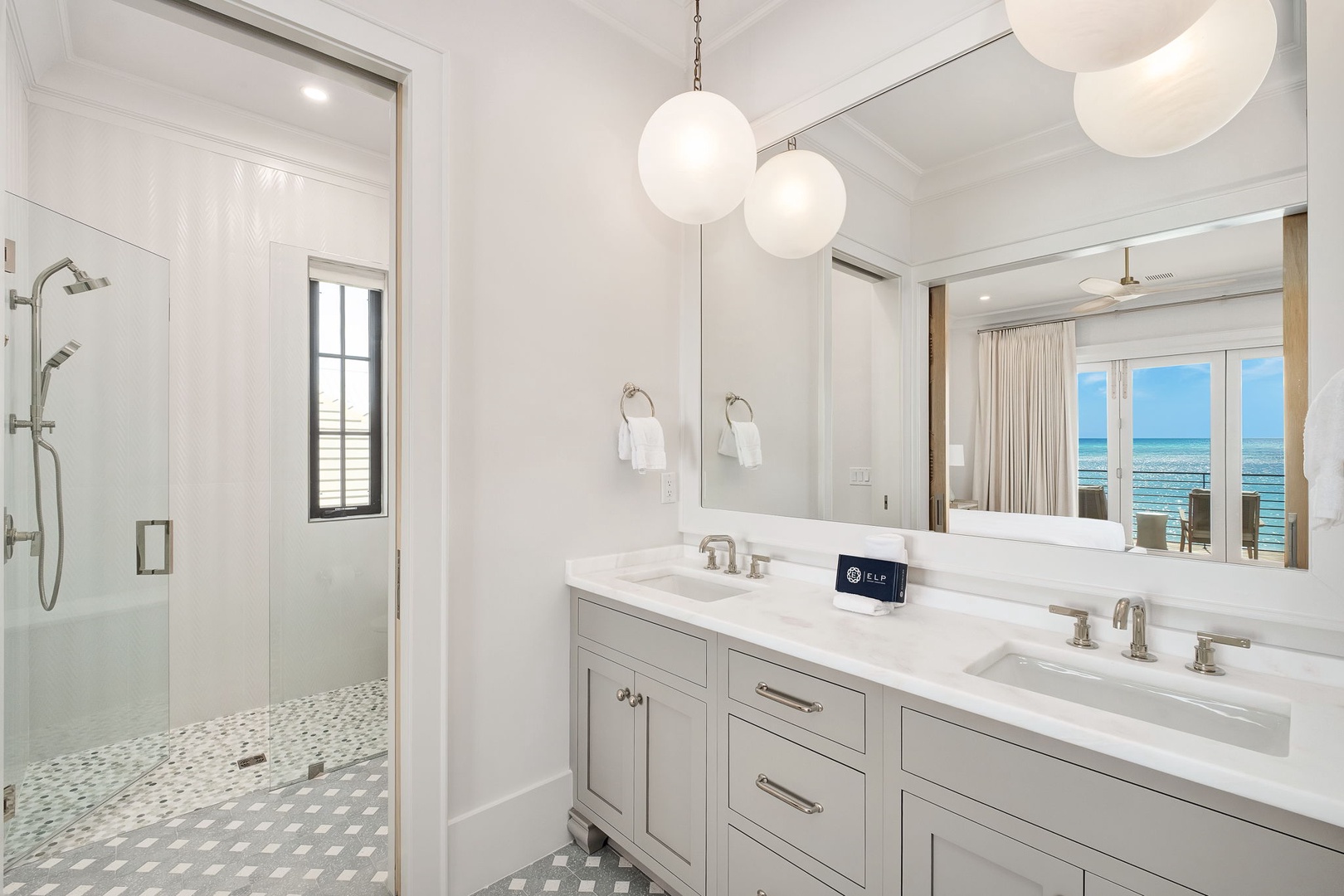 Luxurious dual-sink vanity with marble countertops and elegant pendant lighting creates your perfect morning routine. The walk-in shower awaits just steps away.