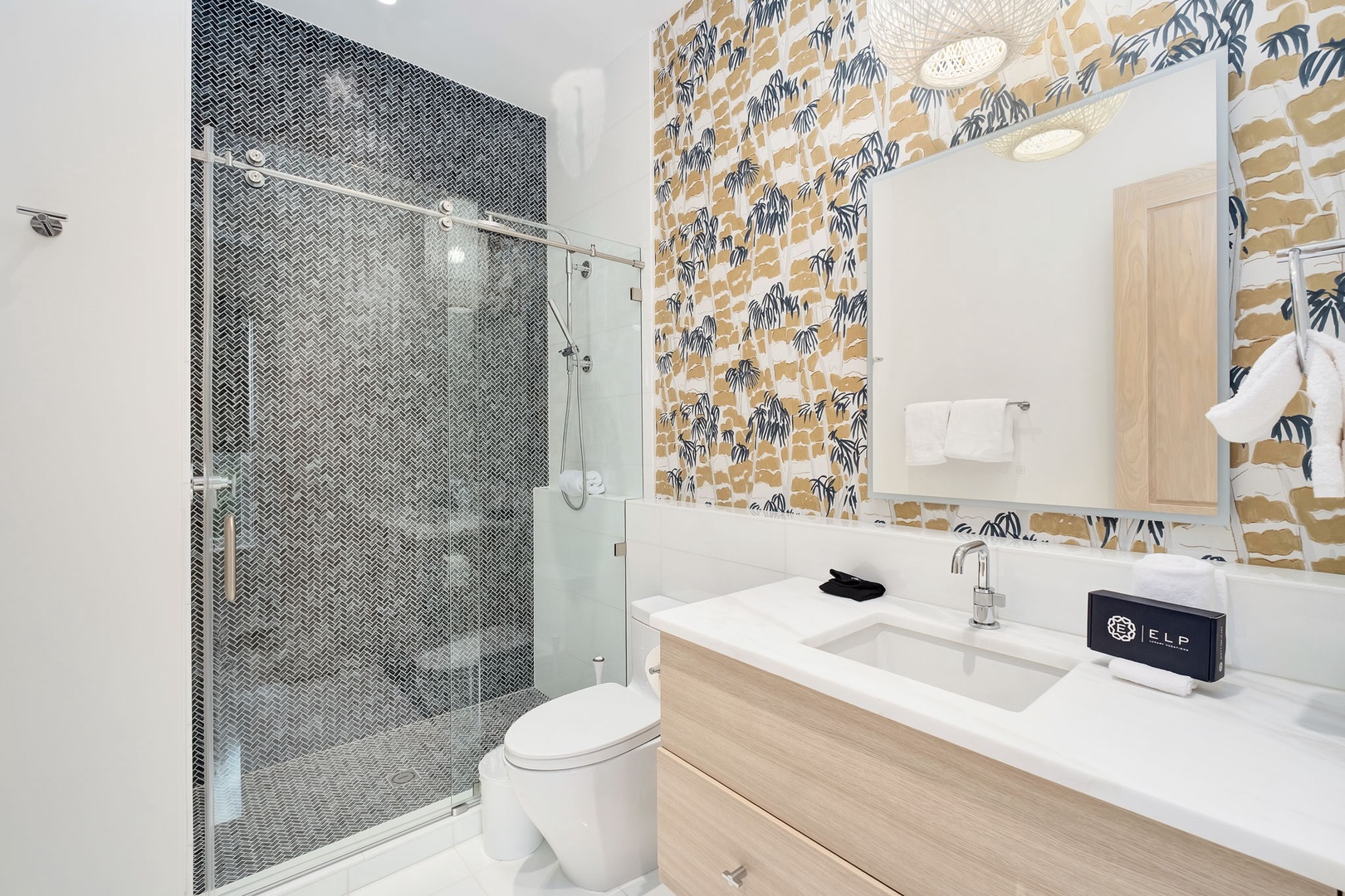 Refresh in your stylish bathroom with a spacious walk-in shower, modern fixtures, and cheerful tropical wallpaper that brings a playful pop of color to your daily routine.