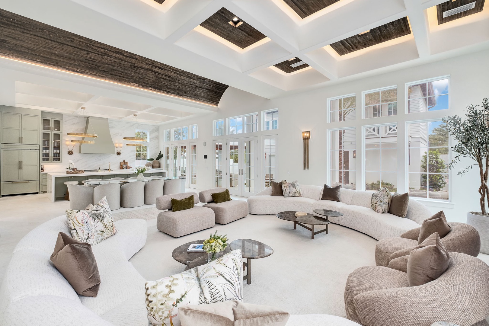 Sink into plush seating in this airy, sunlit living space where soaring coffered ceilings and walls of windows create a bright, welcoming retreat for your stay.