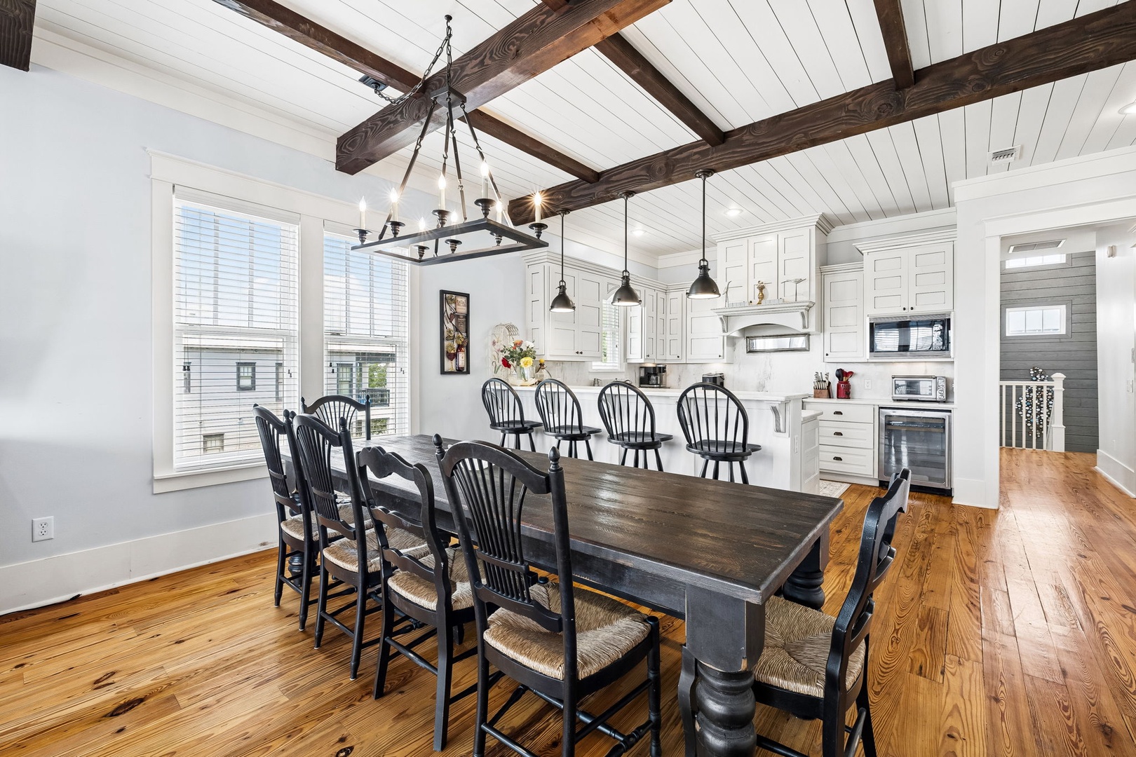 Gather everyone around the farmhouse table beneath soaring wood beams and charming pendant lights. Your open kitchen and dining area blends rustic elegance with modern comfort, perfect for memorable meals together.