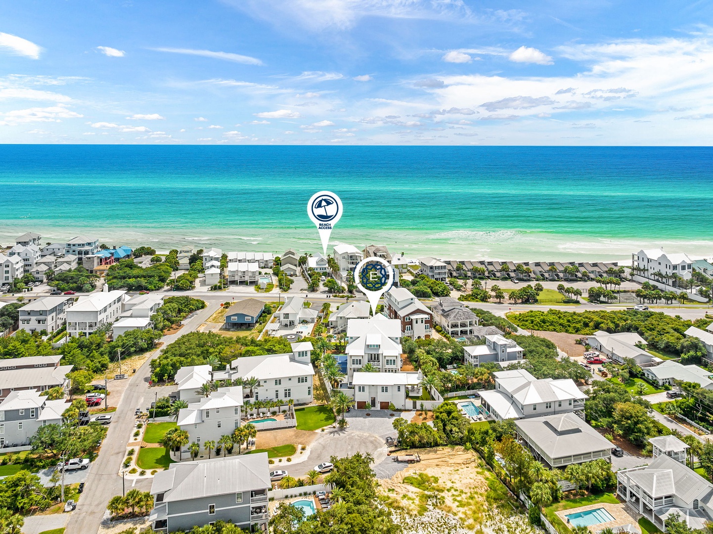 An aerial view showcasing the property nestled in a charming coastal neighborhood, just steps from pristine turquoise waters and soft sandy shores.