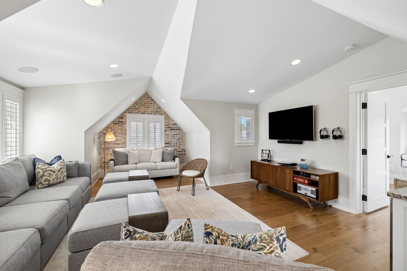 Your spacious retreat features soaring vaulted ceilings and warm wood floors, with exposed brick adding charm to the light-filled sitting nook. Sink into plush seating for movie nights or relaxed conversations.