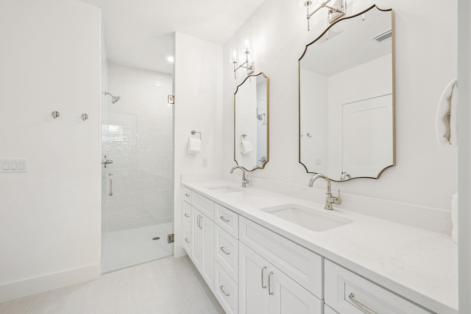 Luxurious dual vanity with elegant mirrors creates your perfect morning routine in this pristine marble sanctuary.