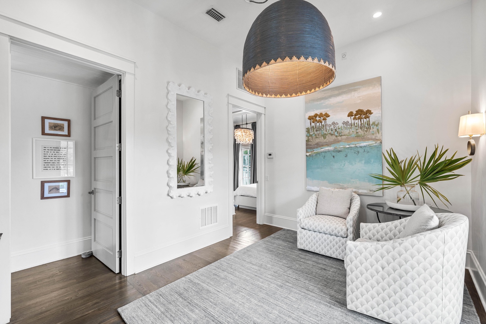 Relax in your elegant sitting area with plush quilted chairs and warm coastal artwork creating the perfect retreat atmosphere.