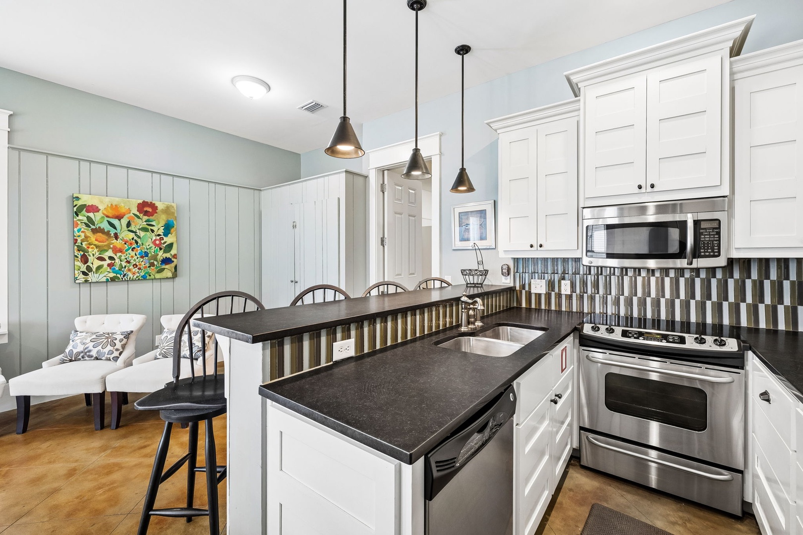 Gather around your fully-equipped kitchen, where modern appliances meet cheerful design. Prepare meals together at the spacious island, bathed in natural light and adorned with stylish pendant lighting.