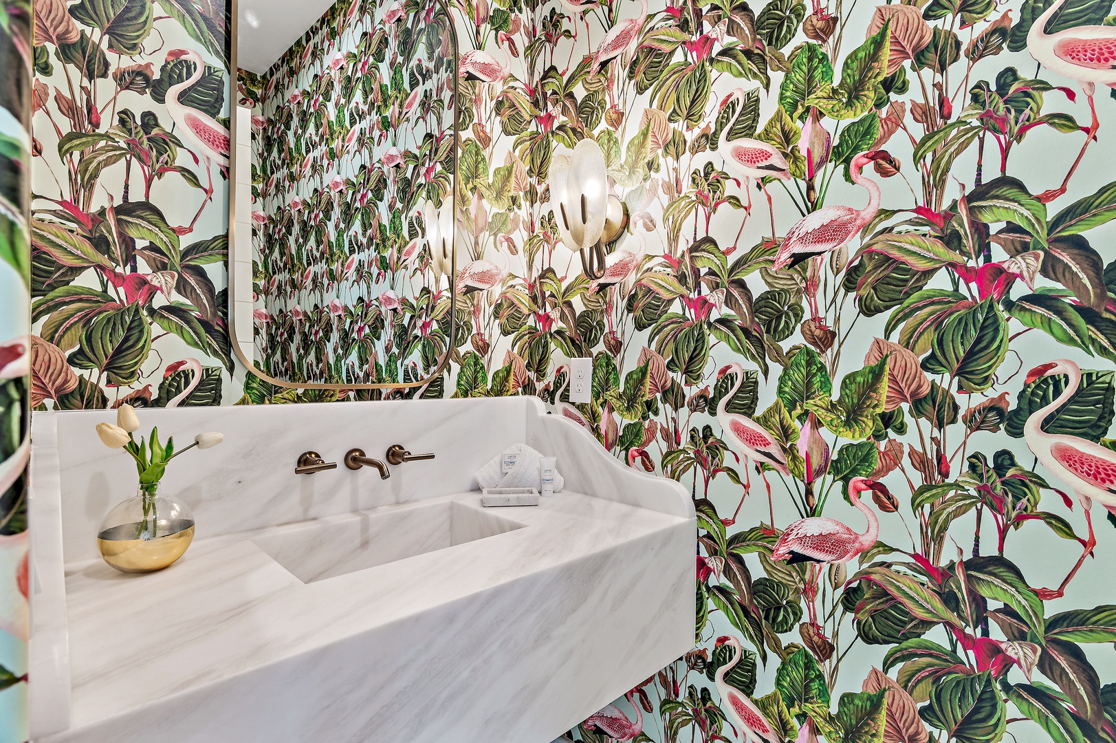 Refresh in your private marble sanctuary, where vibrant tropical wallpaper brings the outdoors in. Modern fixtures meet botanical elegance in this thoughtfully designed space.