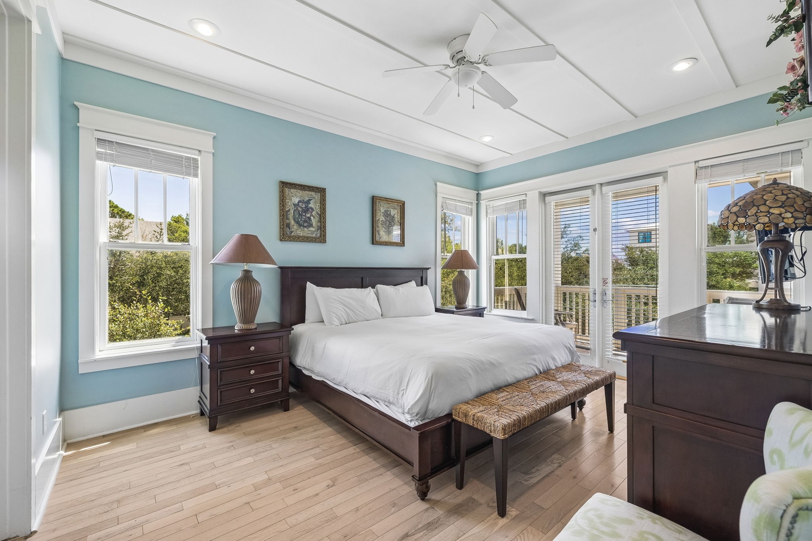 Drift off to sleep in your serene bedroom, where soft blue walls and crisp white linens create a peaceful retreat. Natural light pours through multiple windows, and the ceiling fan keeps you comfortable all night long.