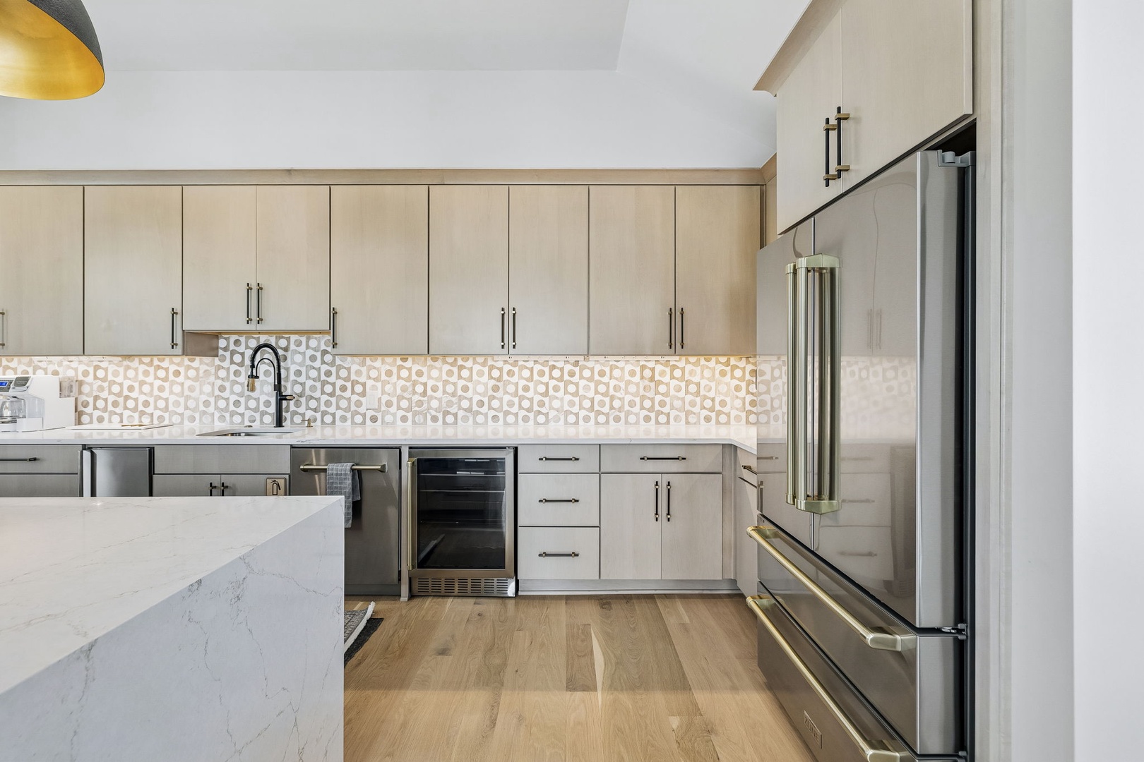 This modern kitchen offers everything you need to prepare delicious meals during your stay, featuring sleek appliances, ample counter space, and a stylish geometric tile backsplash that adds a touch of character.