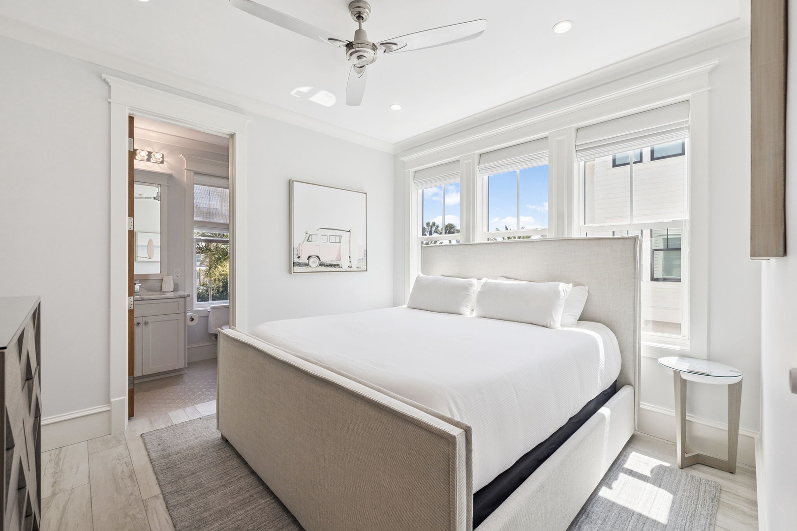 Your bright bedroom welcomes with crisp white linens and peaceful views through gorgeous windows.