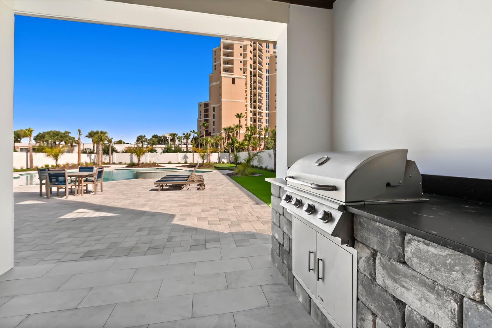 Your own private BBQ station awaits, perfectly positioned on the spacious patio overlooking the pool and palm-lined grounds—ideal for grilling and unwinding under the sun.