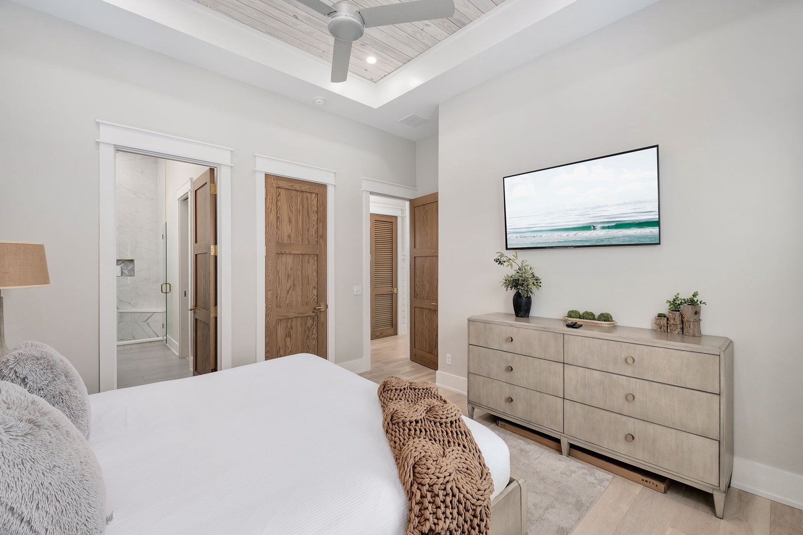 Drift off in your serene bedroom with coastal artwork, modern dresser, and cozy textures creating the perfect retreat.