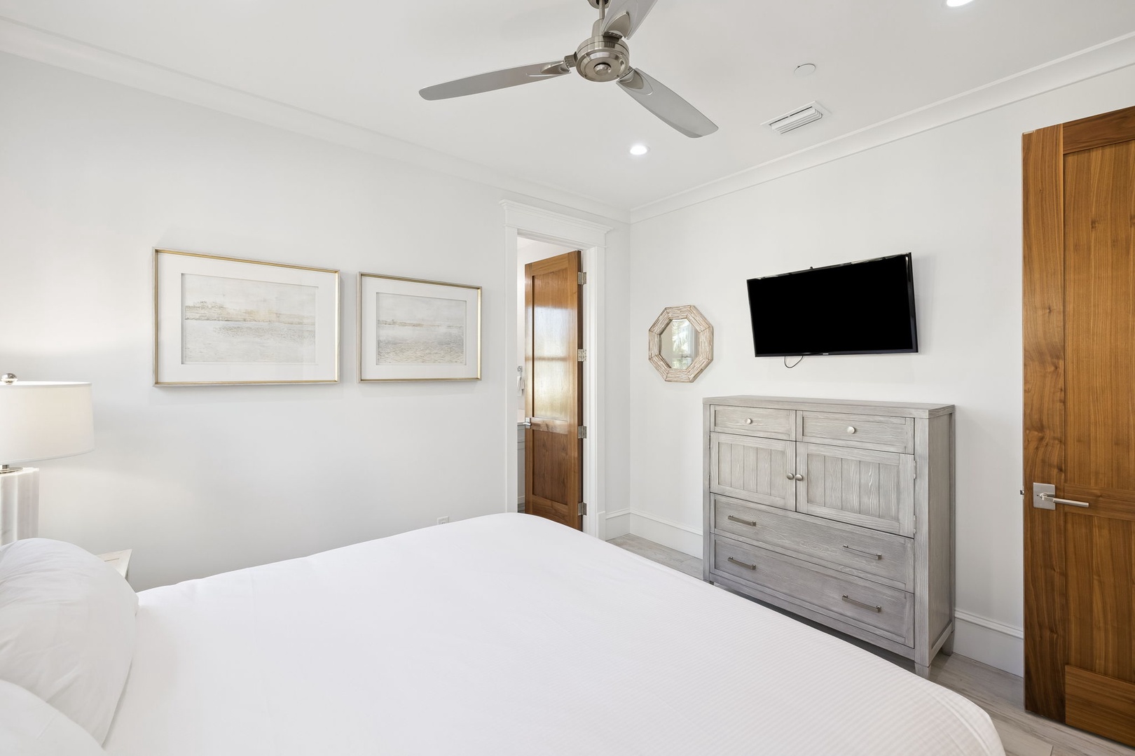 Rest peacefully in your serene bedroom with ceiling fan, flat-screen TV, and thoughtful coastal touches creating the perfect retreat.