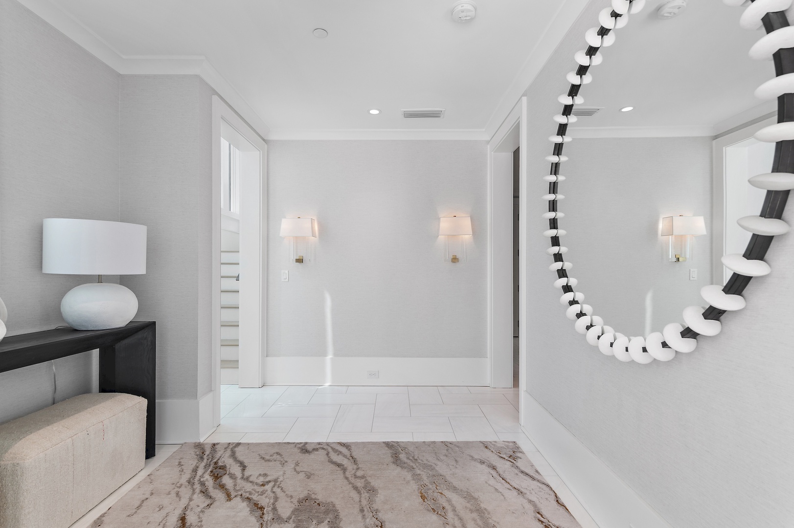 Step into this elegant hallway where soft lighting and chic decor set a sophisticated tone for your stay. The calming neutral palette and contemporary design create a refined welcome as you move through your vacation retreat.