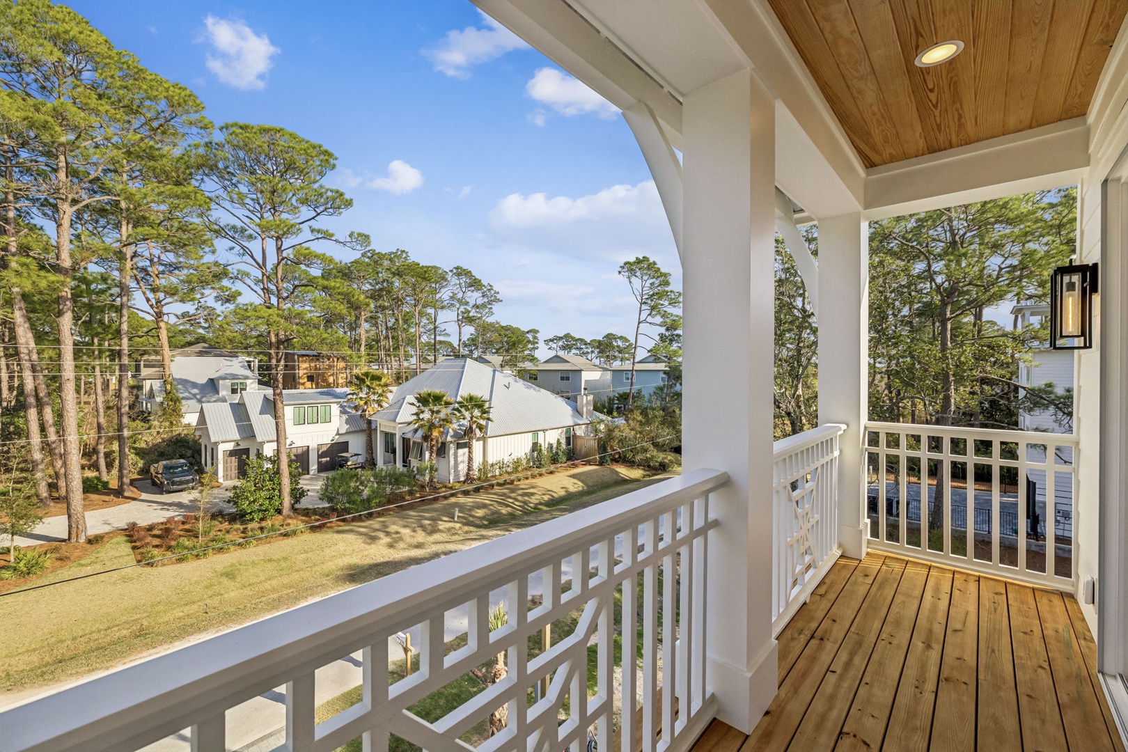 Relax on your private balcony with beautiful neighborhood views, surrounded by lush trees and charming coastal homes.