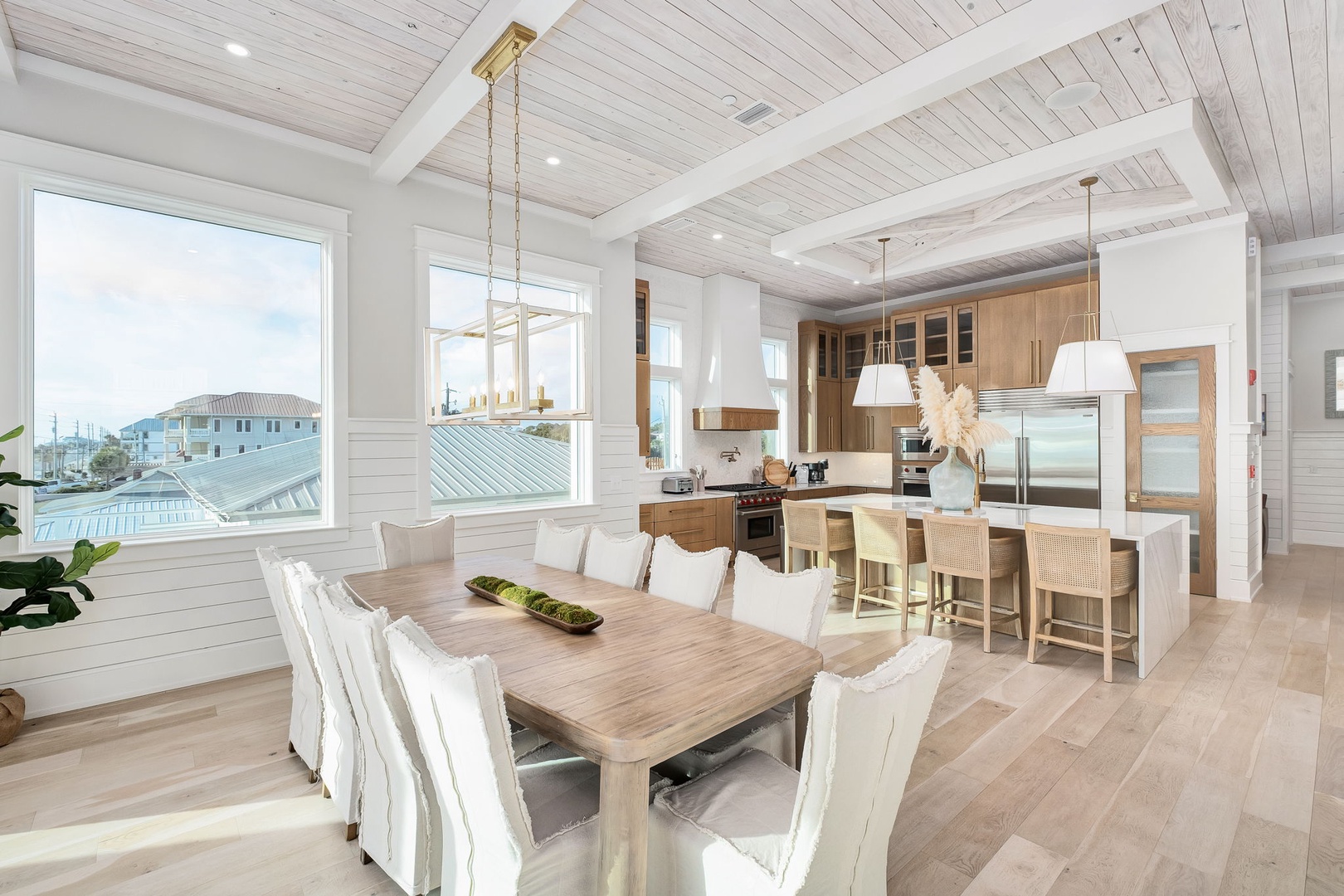 Gather around this stunning dining table while your chef prepares meals in the gourmet kitchen, all bathed in natural light.
