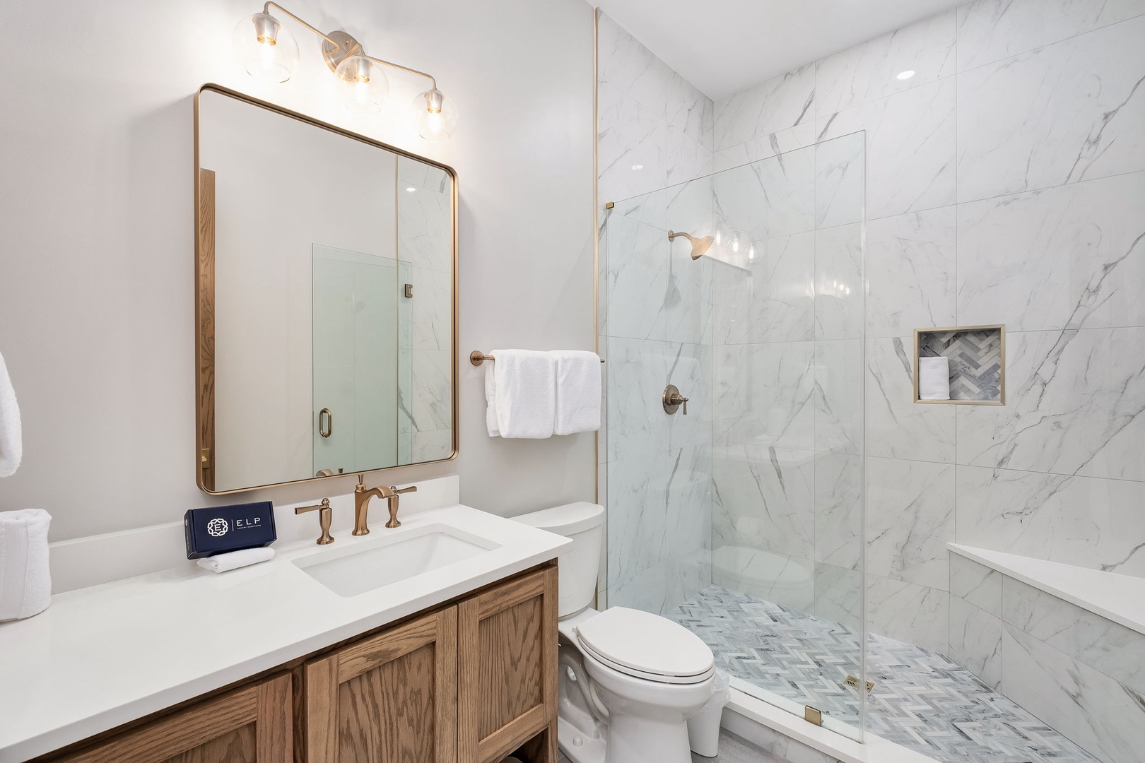 Indulge in your private marble oasis with a rainfall shower and elegant vanity for your perfect morning routine.