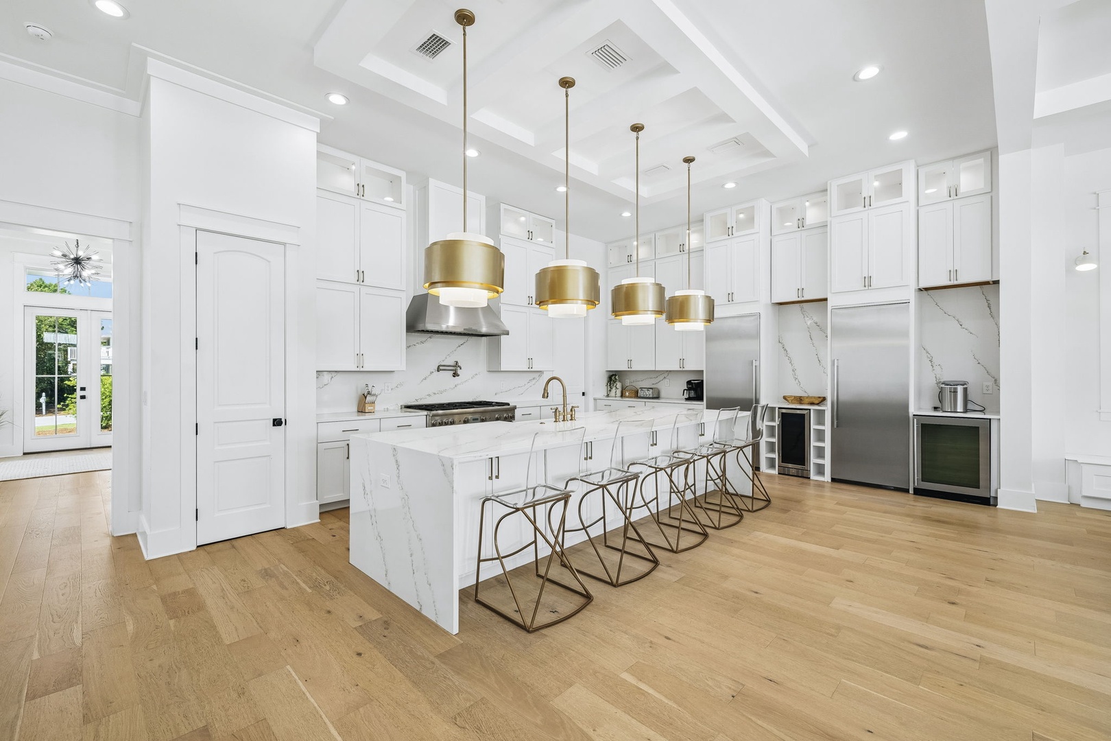 Your gourmet kitchen gleams with pristine white cabinetry, luxe marble countertops, and elegant brass pendant lighting. Gather at the spacious island with friends while preparing memorable meals on top-tier appliances.