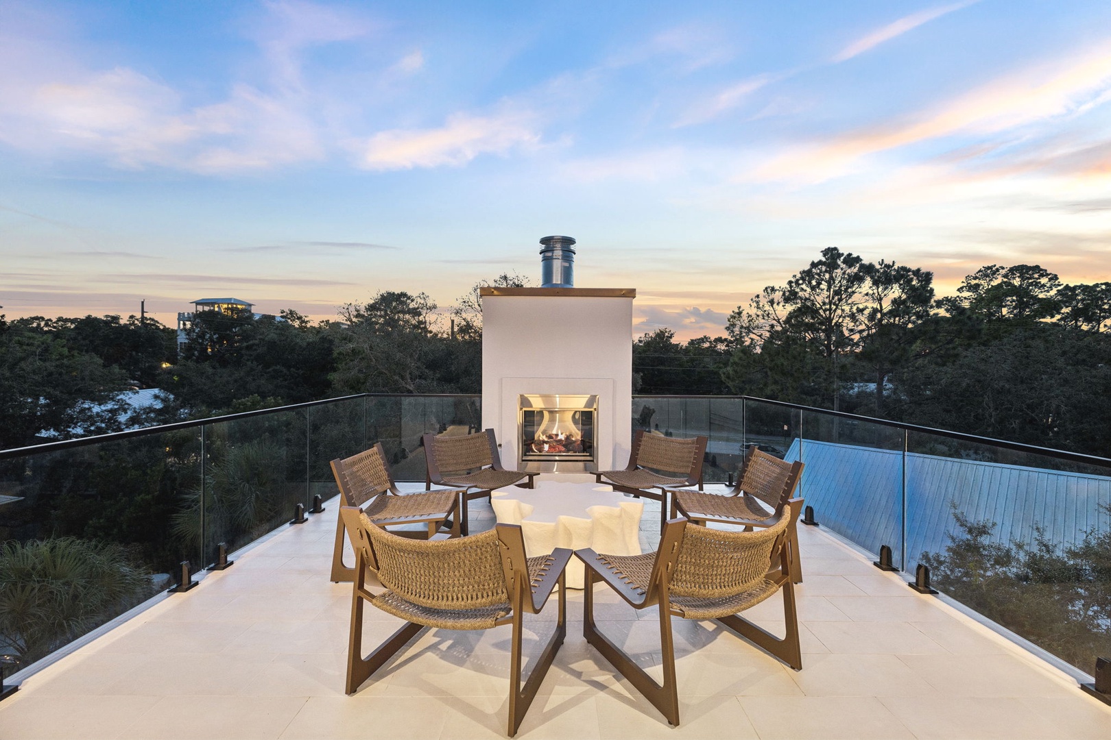 A stunning rooftop terrace where you can gather around the fireplace as twilight colors paint the sky above the surrounding treetops.