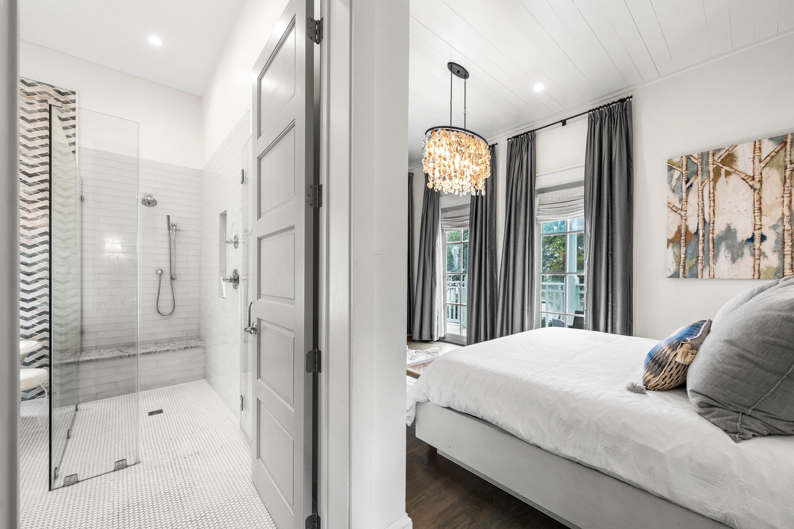 Rest in your serene bedroom suite with crisp linens, elegant chandelier, and a spa-like ensuite shower just steps away.