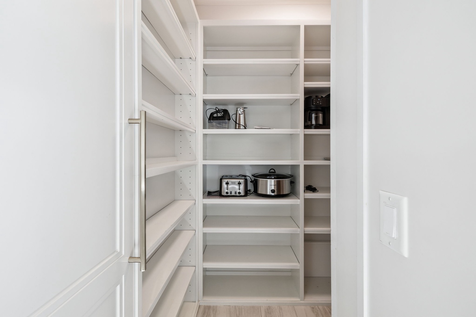 Your spacious pantry keeps everything organized, with plenty of shelving and handy appliances like a slow cooker and toaster ready for your use.