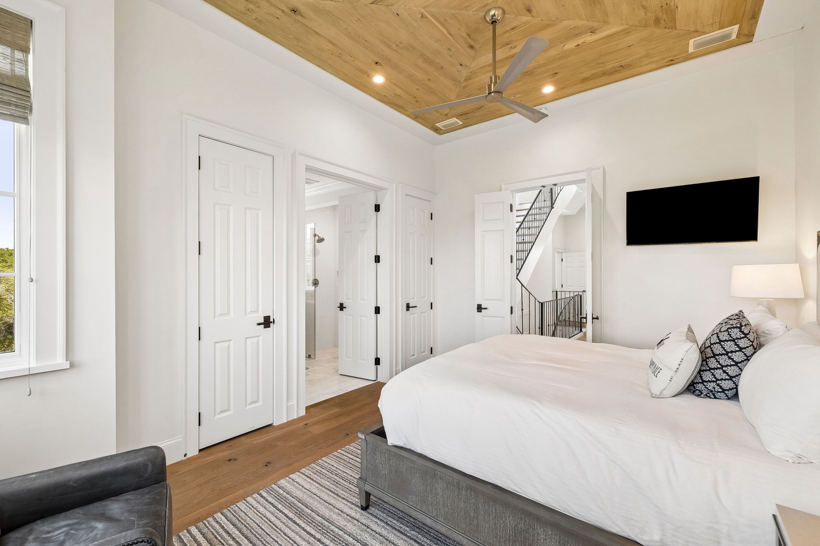 Drift off beneath the stunning wood-planked ceiling, where warm natural light and a cozy reading chair create your perfect retreat. The en-suite access ensures your comfort and privacy.