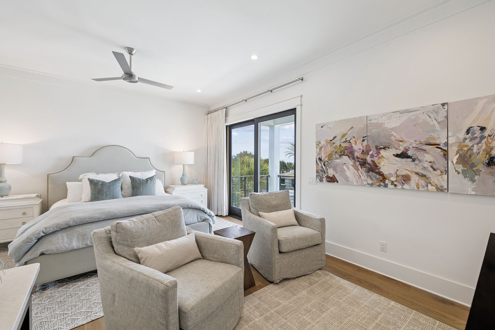 Rest in your serene bedroom featuring plush seating, elegant artwork, and calming views from your private balcony.