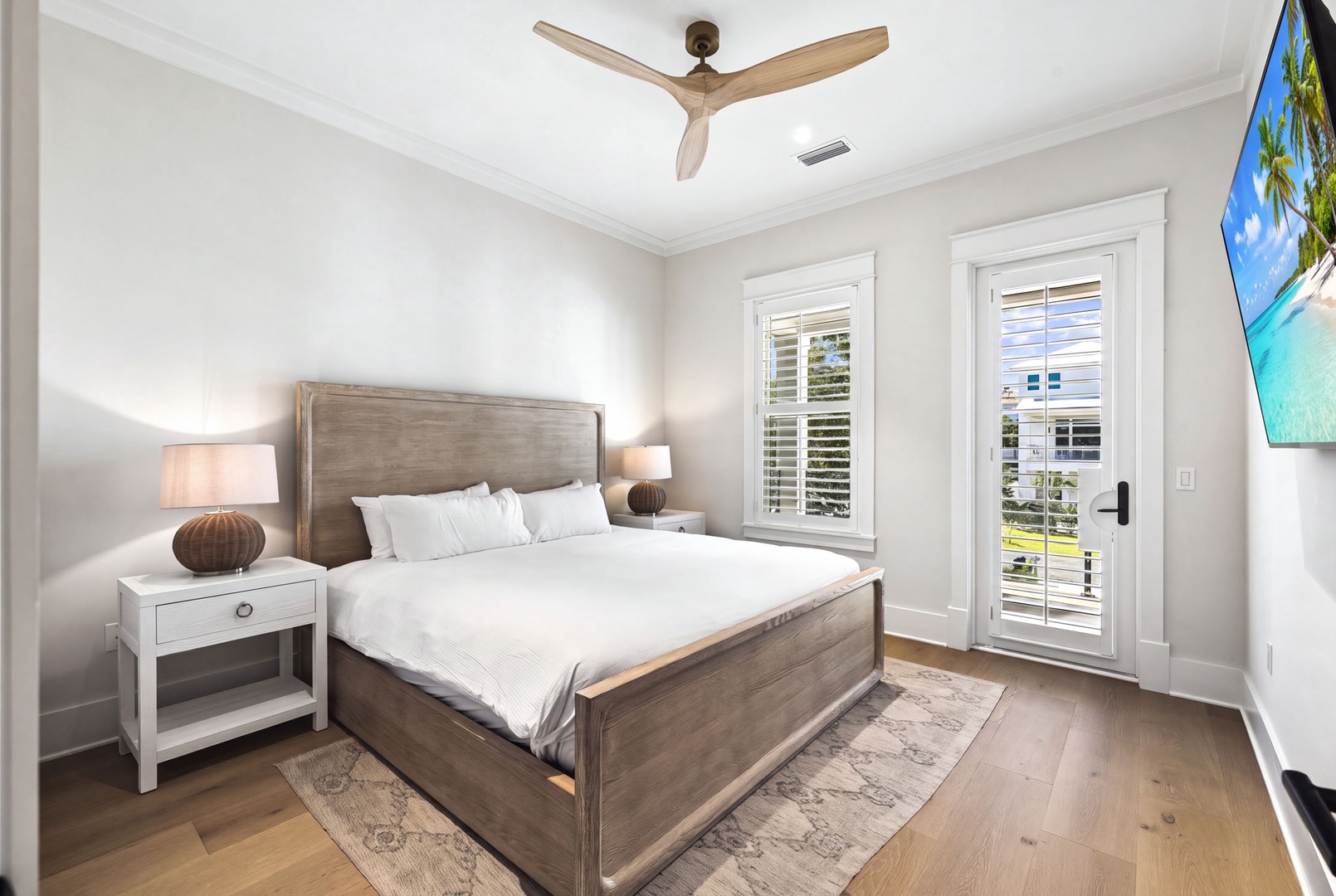 Sink into fresh linens in your peaceful bedroom retreat, where soft natural light filters through plantation shutters and a gentle ceiling fan keeps you comfortable all night.