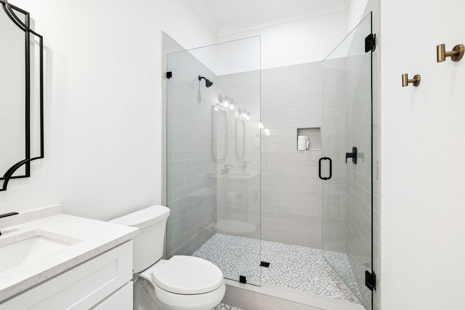 Step into your sleek bathroom featuring a spacious walk-in shower with rainfall head and elegant brass fixtures for your refreshing moments.