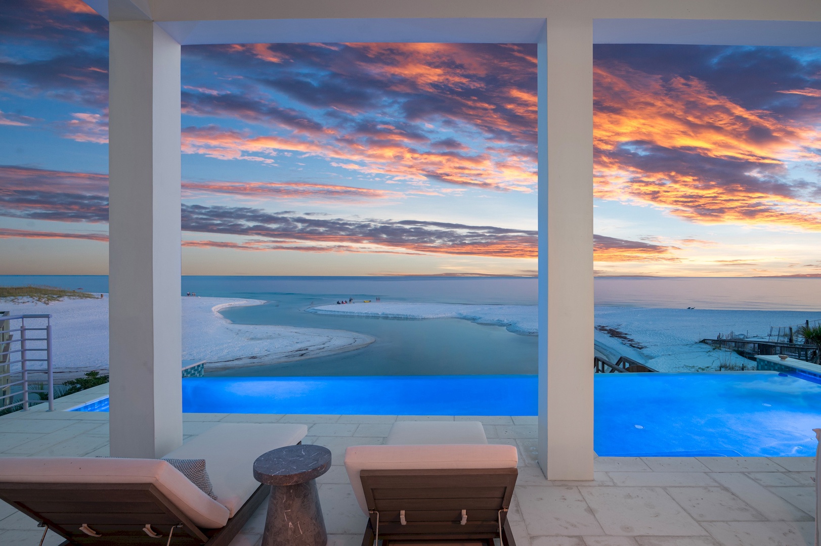 Stunning sunset views from the infinity pool terrace, where the sky's vivid oranges and blues stretch endlessly over the turquoise water.