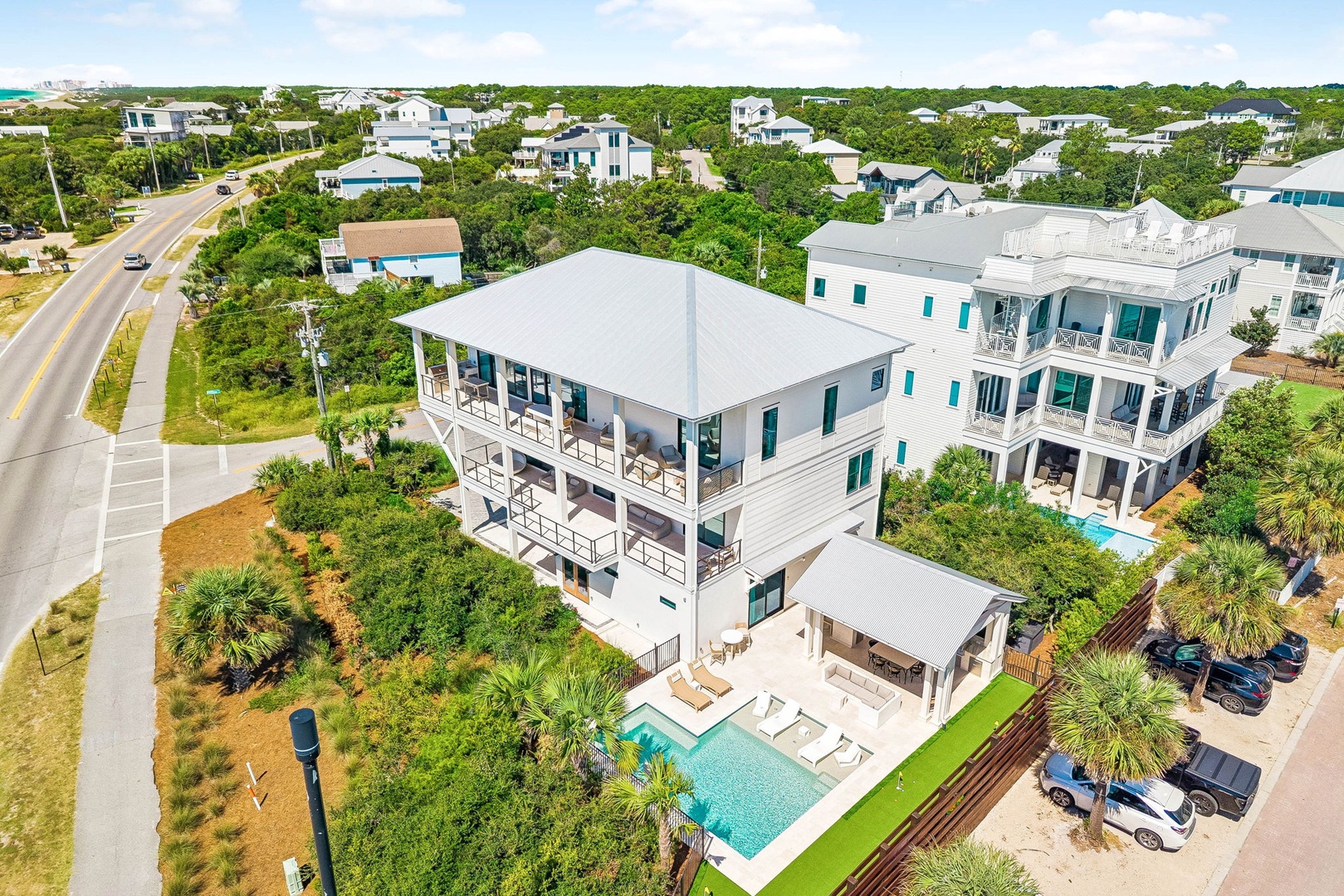 This impressive three-story coastal home features expansive porches, a private pool, and abundant outdoor space in a peaceful beachside neighborhood.