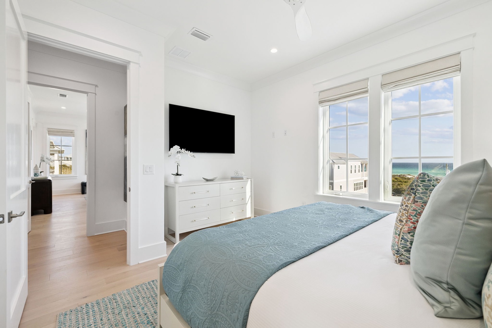 Drift off peacefully in your airy bedroom with ocean views through oversized windows and coastal-inspired decor.